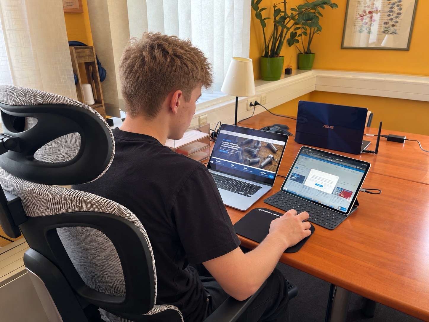 Egy diák a laptopja és táblagépe előtt, a képernyőkön a megújult Menet-Trend oldalak