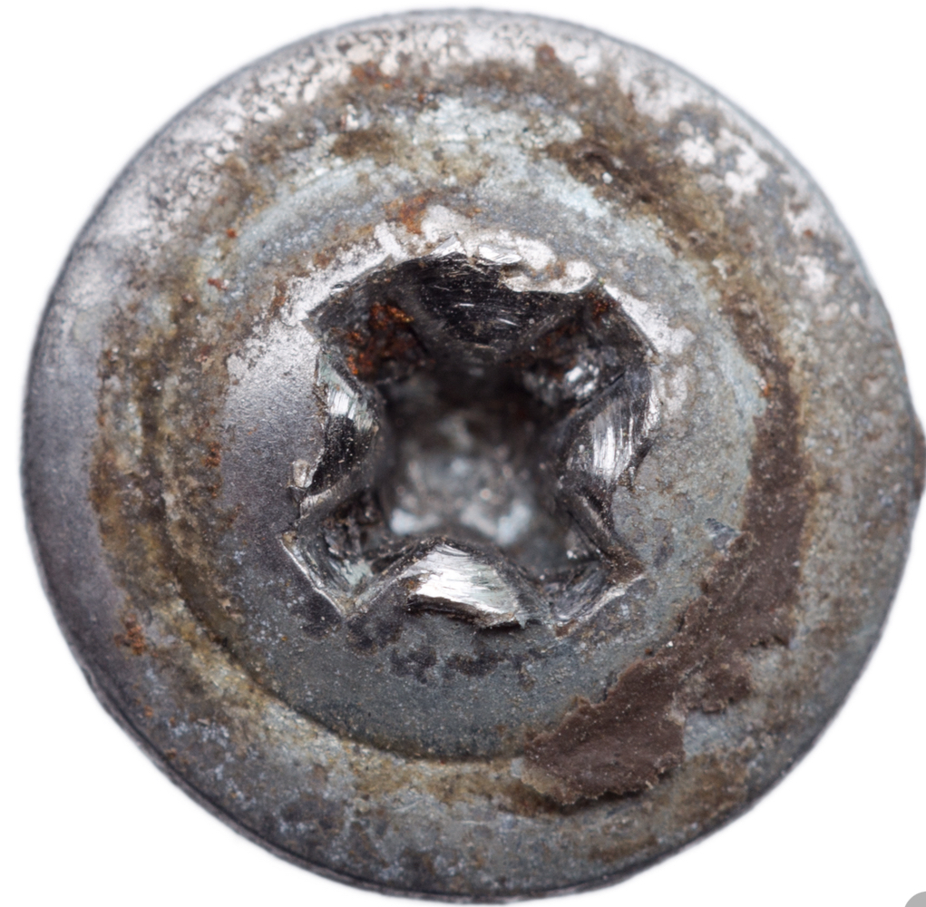 A rusted screw head with a chewed-out Torx drive